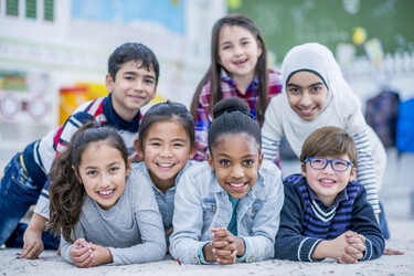 seven elementary school students smiling at the camera