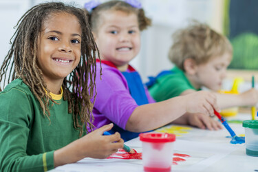 three kindergarten students painting