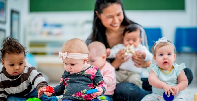 a child care worker with a group of babies and toddlers